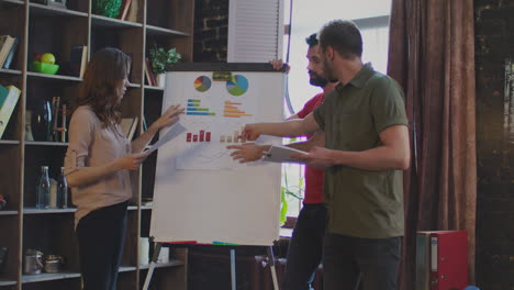 Junge-Geschäftsleute-Streiten-über-Geschäftsplan-Auf-Whiteboard-Im-Büro