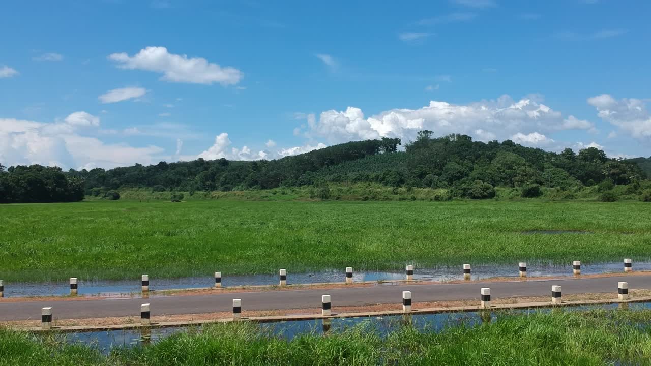 Motorbike rider on Indian village road,Bike Rider,Road between river,beautiful Sky