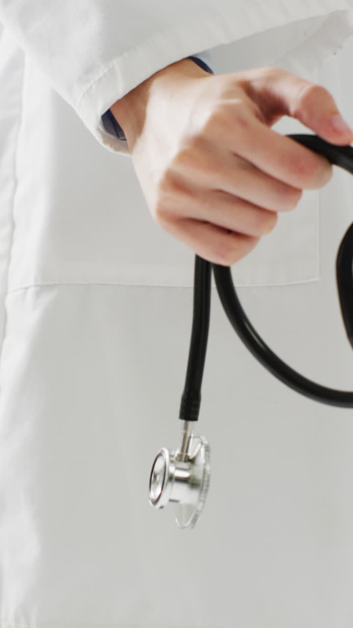 Video vertical de mano de doctora caucásica sosteniendo un estetoscopio, con espacio para texto.