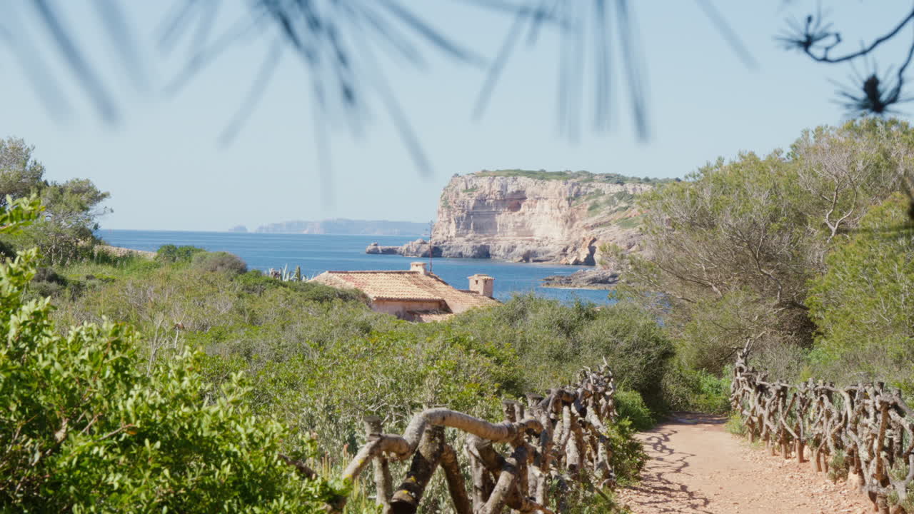 A picturesque path leading to the water's edge on Mallorca, captured in a wide shot, inviting viewers into a serene journey