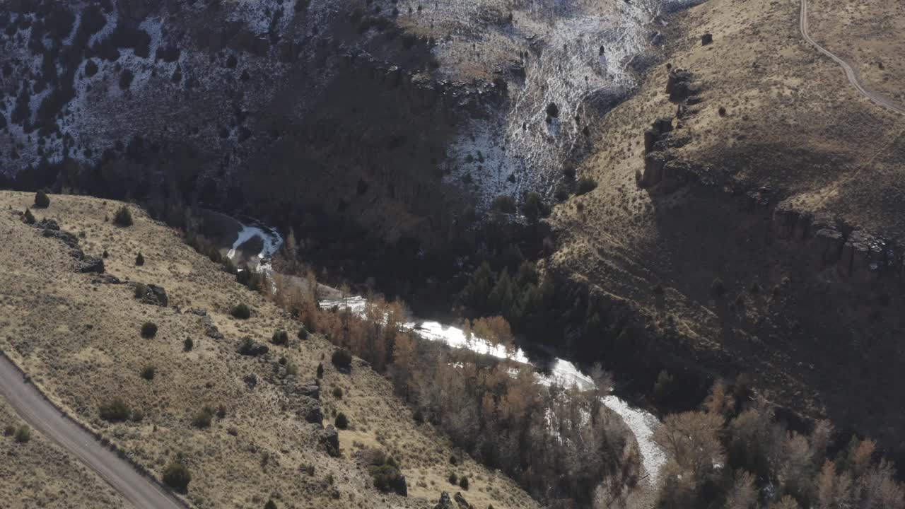 un dron baja sobre un cañón en la zona rural de idaho con nieve derretida