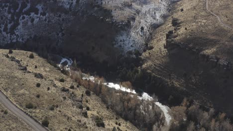 a drone lowers over a canyon in rural idaho with melting snow