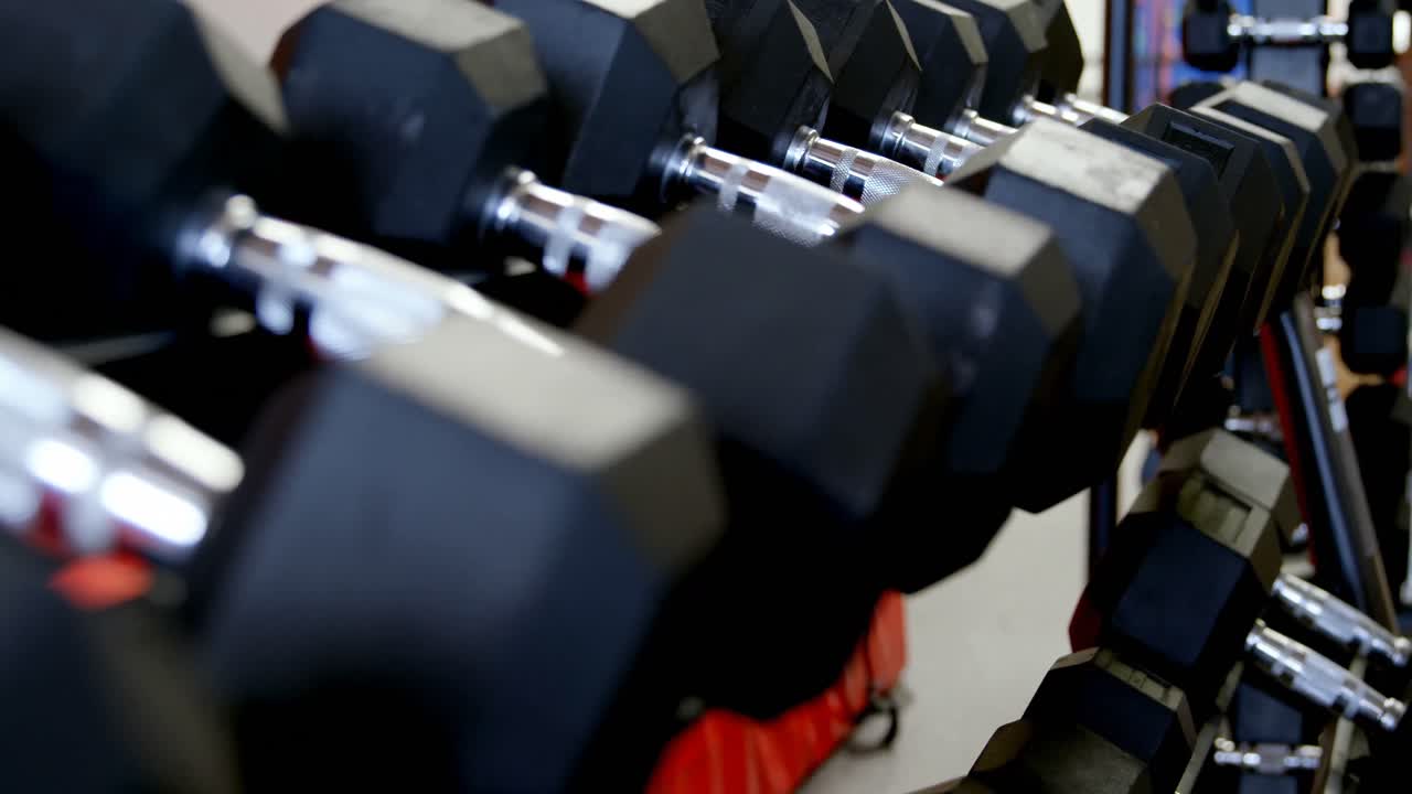 Dumbbells on a rack in fitness studio 4k