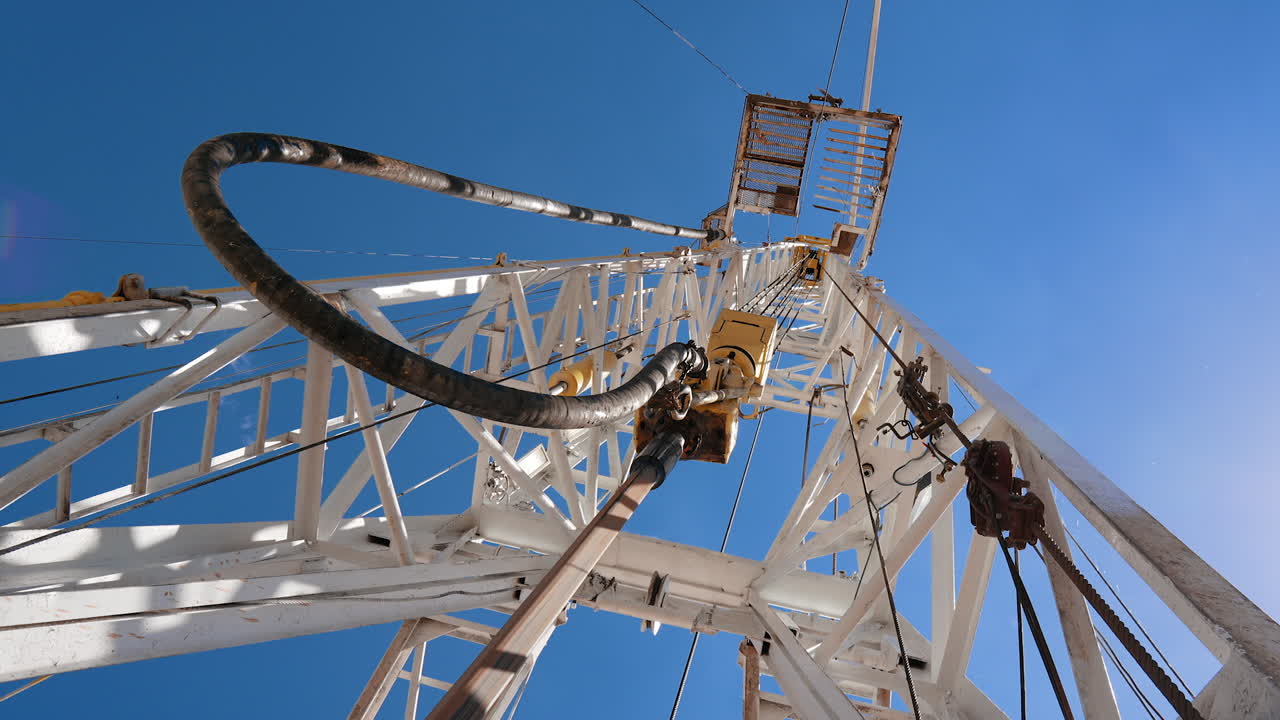 Oil rig with the rotating pole in the center. Low angle view at the tower drilling the natural resources.