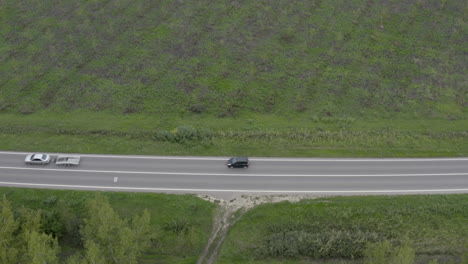 兩輛汽車沿著森林景觀的道路行駛的空中拍攝,無人機pov