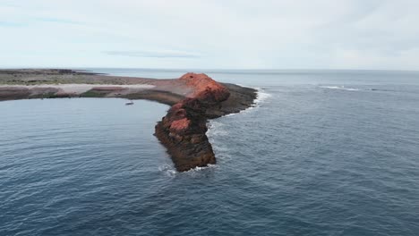 boat floating on sea near rocks