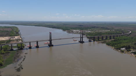 drone view of justo jose de urquiza bridge above the wide parana guazu river, a vast waterway, buenos aires argentina. flying to the right