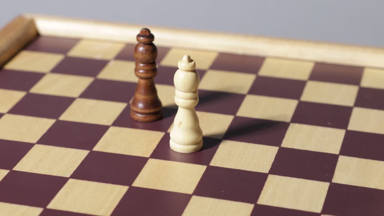A white and black bishop chess piece stand on a chessboard that's spinning around