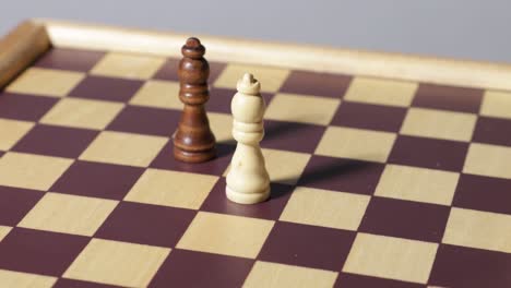 a white and black bishop chess piece stand on a chessboard that's spinning around