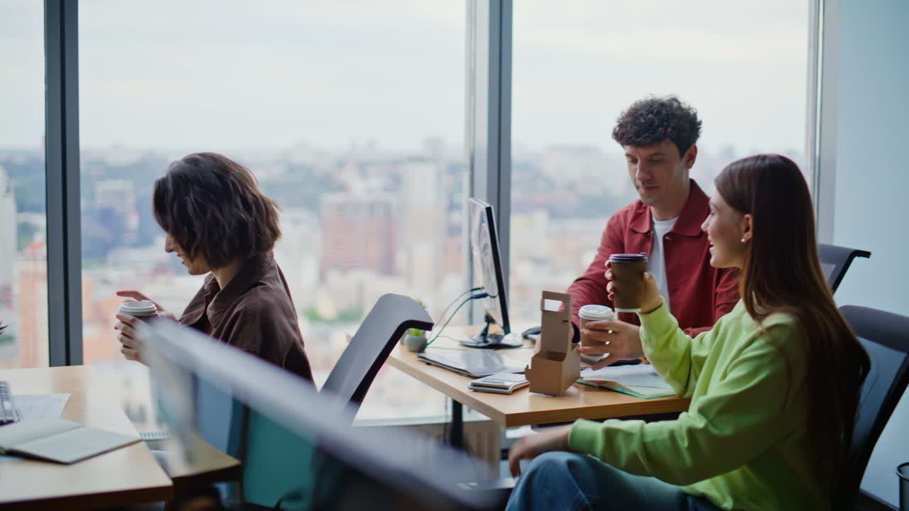 Smiling woman bringing coffee to colleagues at room. People enjoying work break