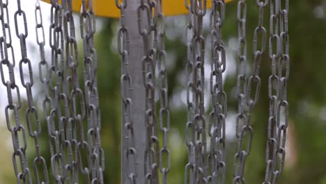 disc golf disc sinks in to the basket chains - close up shot