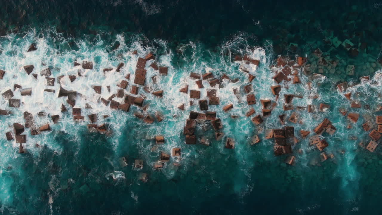 Top view from right to left, Steep volcanic shore, reefs of volcanic lava, stormy ocean, white foam from the giant waves that hit rocks. Garachico, Tenerife, Canary Islands.
