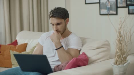 Concentrated-man-working-on-laptop-computer-at-home.-Serious-businessman