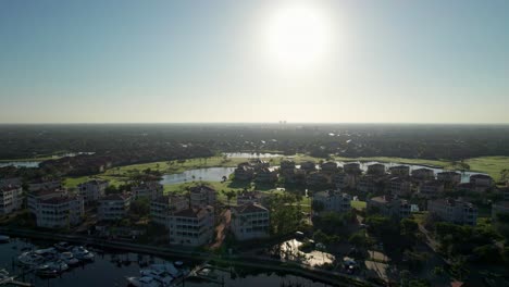 Cinematic-drone-aerial-view-of-the-bright-sunrise-over-a-golf-course