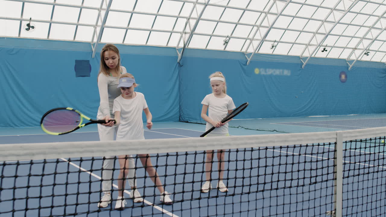 Girls Having Tennis Training With Coach Indoors