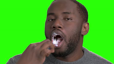 african american man brushing his teeth.
