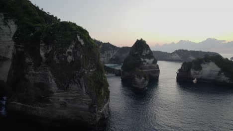 Flying-Through-Limestone-Cliffs-Toward-Diamond-Beach-At-Sunset-In-Nusa-Penida,-Bali,-Indonesia