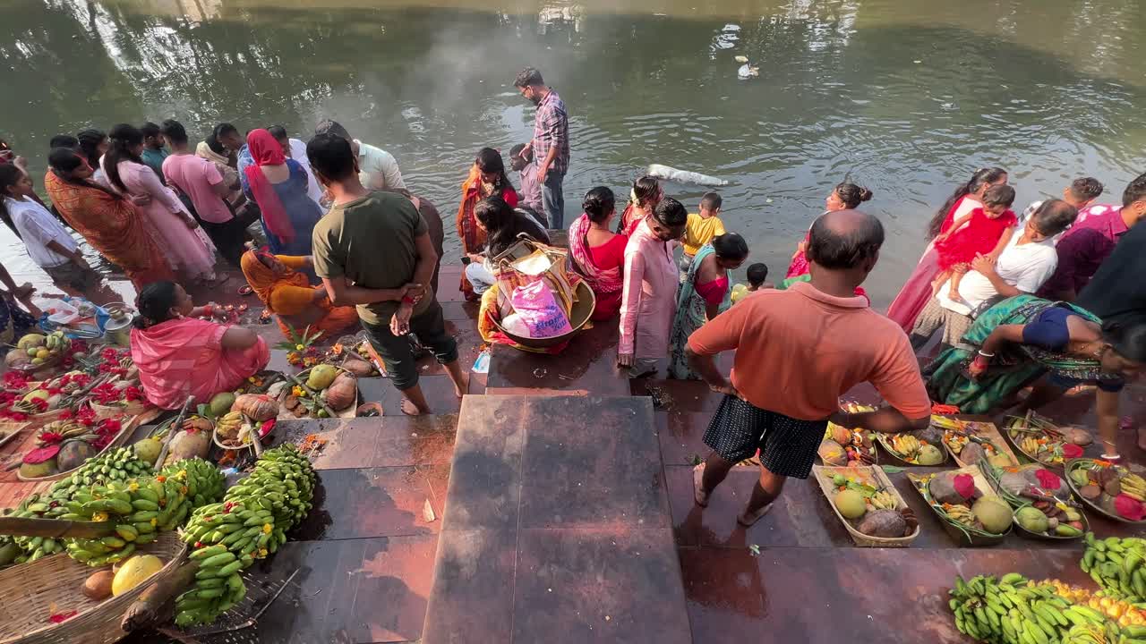Profile view of devotees at ghat during Chath Puja argh in Kolkata, India.