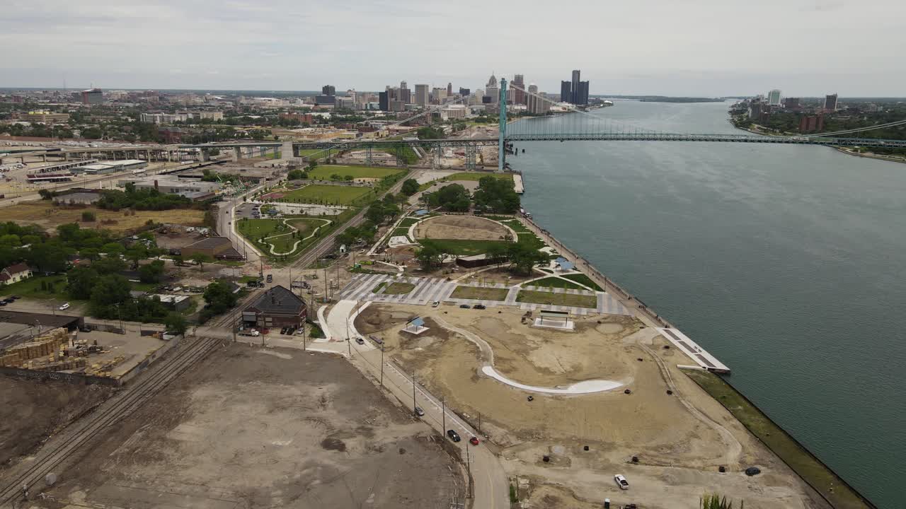 parque ribereño en construcción con puente embajador y horizonte de detroit, vista aérea