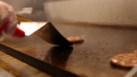 professional chef cooking hamburger meat patties to perfection