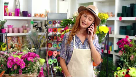 Female-florist-talking-on-mobile-phone-in-flower-shop