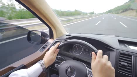 hands holding the steering wheel while driving.