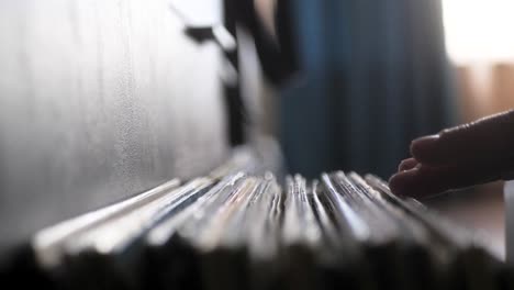 male hands going through vinyl records, close up view