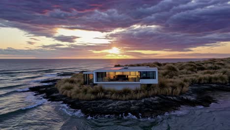 luxurious modern beach house perched on small island, overlooking serene ocean waters bathed in golden sunset light, embodying peaceful architectural harmony