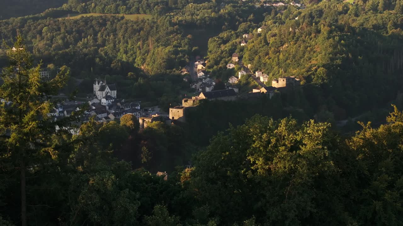 Castle overlooking a village in a forested hillside