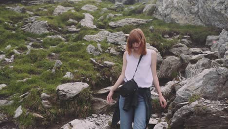 a young woman hiker climbs mountains with photo camera. transfagarasan, carpathian mountains in romania