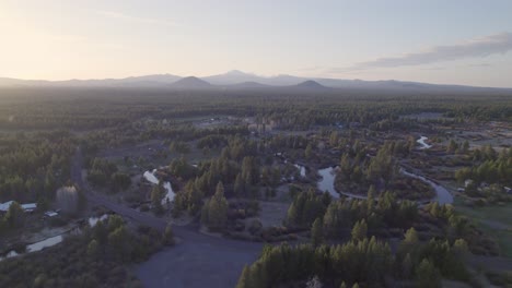 High-drone-shot-slowly-pushes-in,-capturing-the-Three-Sisters-in-Bend,-Oregon,-during-a-warm-sunset