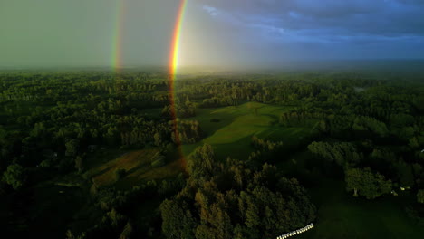 double rainbow over woodland landscape, aerial drone view