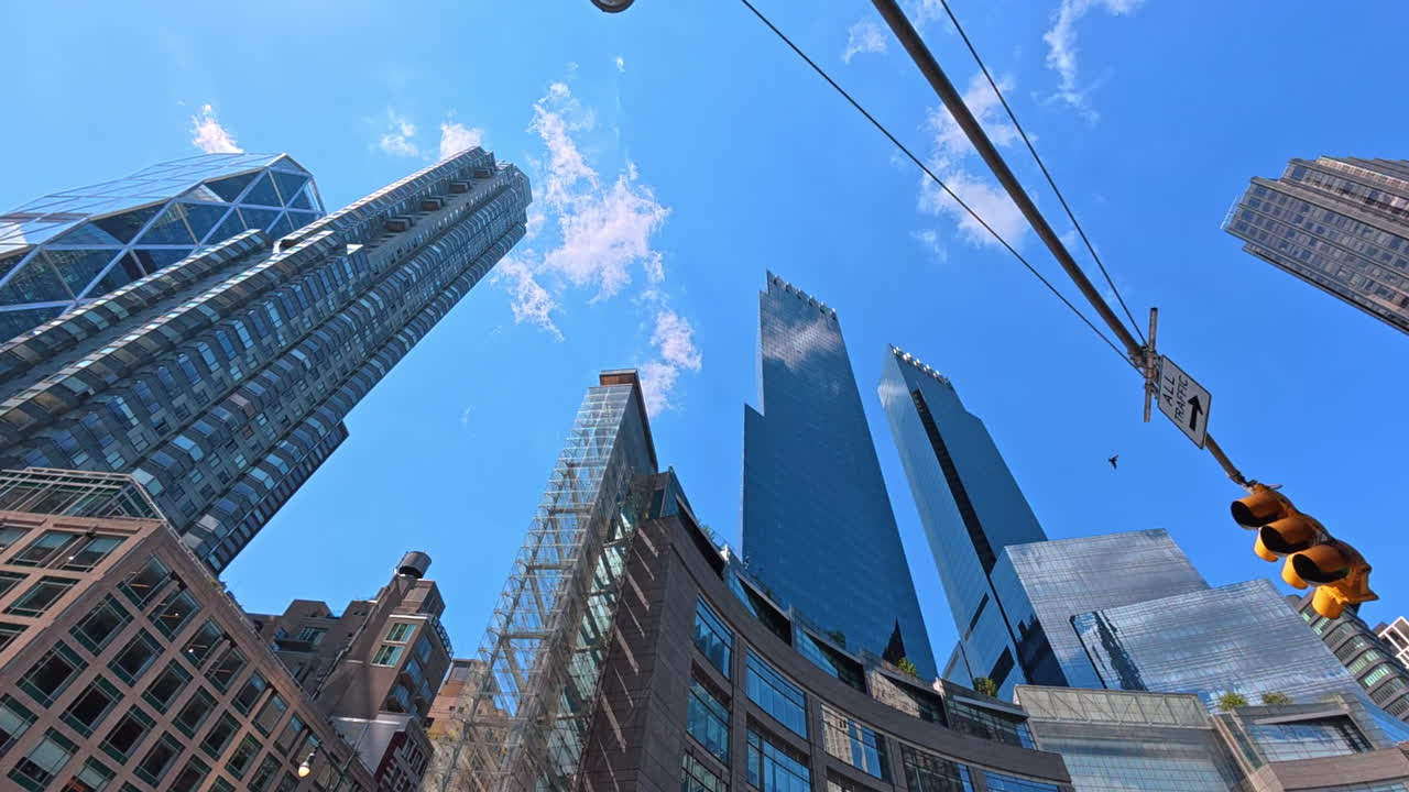 New York, USA, 1 August 2025: Looking up at skyscrapers near Columbus Circle. Dramatic upward view of Manhattan skyscrapers with modern glass facades and clear blue sky