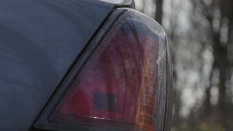 in der nähe von einem vernachlässigten auto blinken hintere gefahrenscheinwerfer auf einer abgelegenen waldstraße.