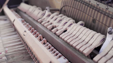 Closeup-of-Old-Dusty-Piano-Hammers-Hitting-Strings