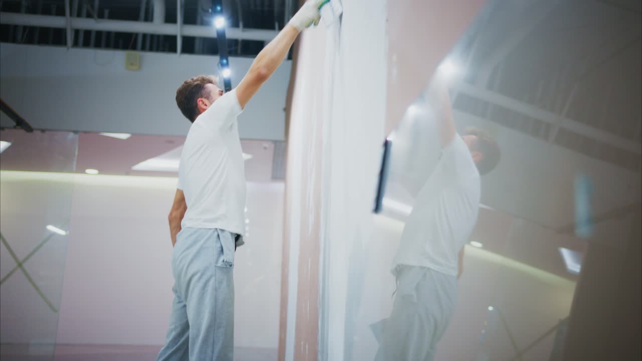 A Dedicated Worker Engaged in Wall Preparation and Finishing Techniques, Applying Spackle for a Smooth Surface in a Professional Environment