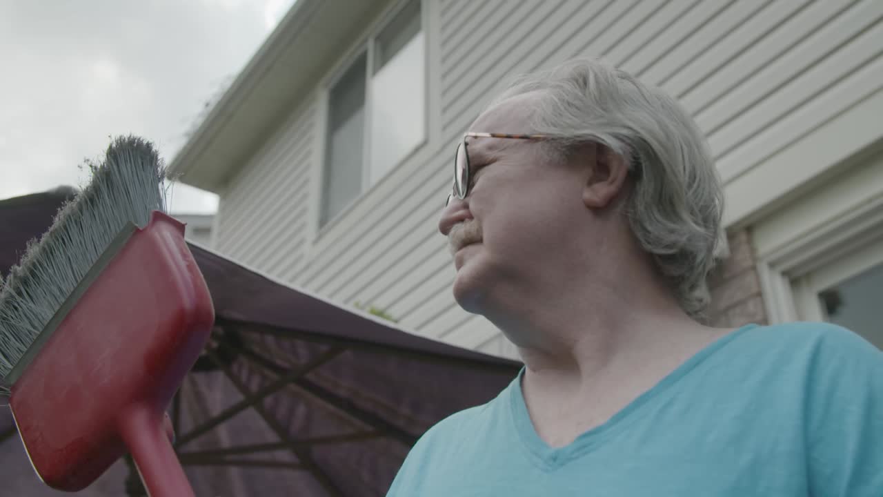 뒤돌아보고 네 번째 빗자루를 들고 남자