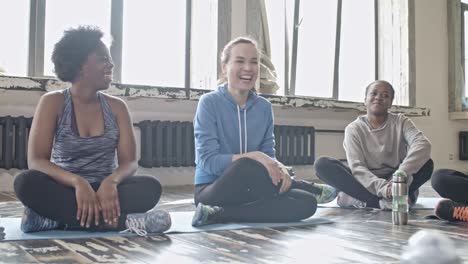 sporty women sitting in circle and chatting