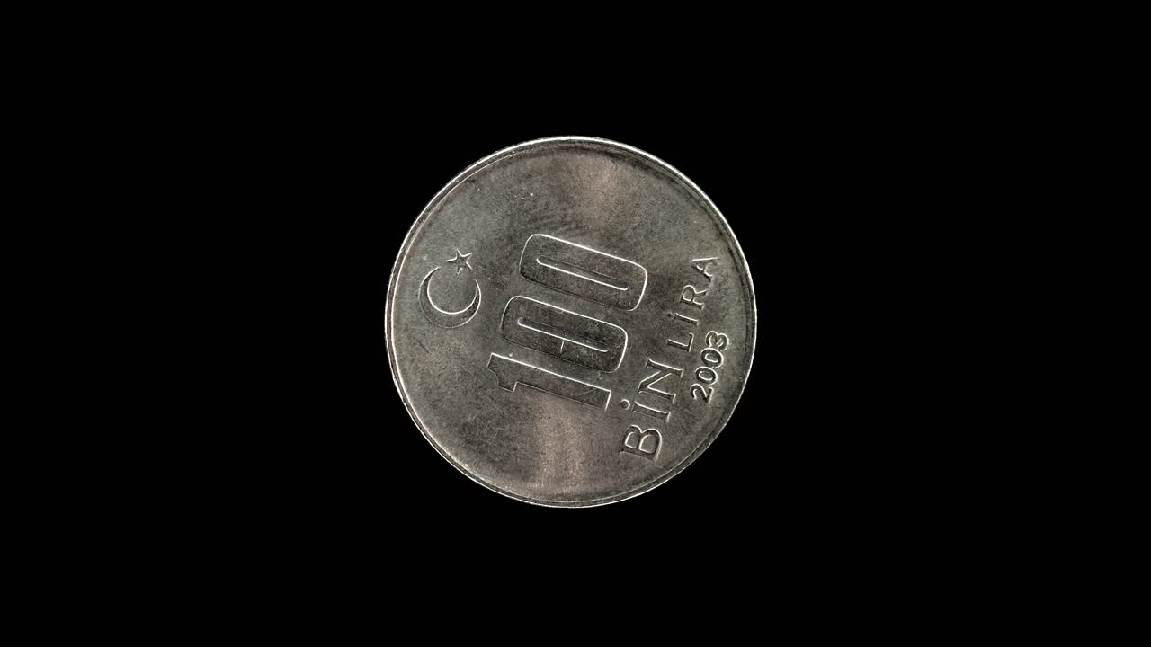 Turkish 100 Bin Lira coin from 2003 rotating against a pure black background with copy space