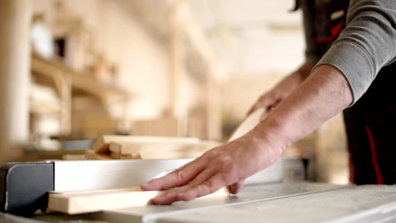 manos irreconocibles hábil fabricante de muebles cortando tablas de madera con sierra circular eléctrica