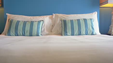 pan a través de una cama de hotel resort decorada con almohadas decorativas a rayas