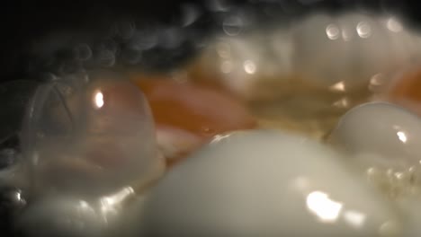 Big-bubbles-of-egg-white-with-yellow-yolk-in-the-background-with-soft-bokeh-of-frying-eggs-for-breakfast