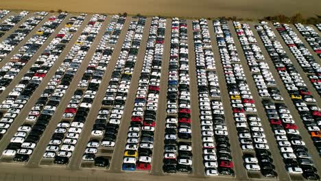 aerial footage of finished cars ready to be shipped on huge distribution center