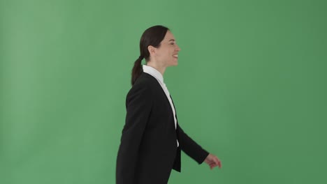 happy businesswoman walking over green background