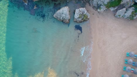 Aerial-Dolly-über-Türkisfarbenem-Wasser-Am-Strand-Neben-Felsen