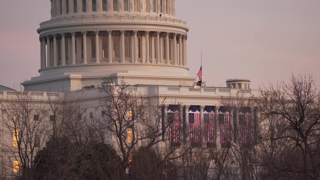 Campidoglio degli Stati Uniti al tramonto con bandiere esposte per l'inaugurazione di Joe Biden, Washington D.C.