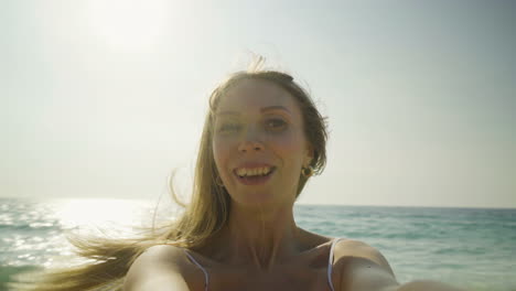 happy young woman turning around on beach