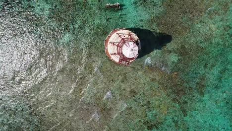 a fly-over drone shot of an abandoned lighthouse, in a remote area of the caribbean sea, near bimini, bahamas