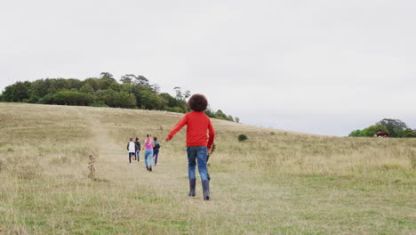 vista trasera de un grupo de niños en un viaje de acampada de actividad al aire libre subiendo una colina