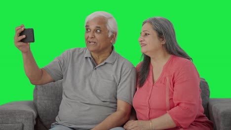 Happy-Indian-old-couple-making-vlog-for-social-media-Green-screen